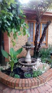 a fountain in the middle of a garden at Ridderspoor Guesthouse in Middelburg