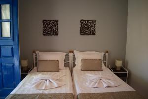 dos camas sentadas una al lado de la otra en un dormitorio en Embati Folegandros rooms en Chora Folegandros