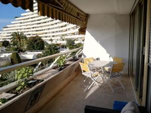 a balcony with a table and chairs and a building at VILLENEUVE LOUBET- MARINA BAIE DES Anges -AU BON VIVRE - 2 pièces- Le Ducal - 60m2 Luxe in Villeneuve-Loubet