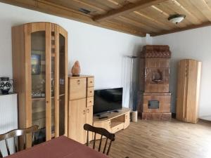 a living room with a television and a table and chairs at Gästehaus Falkenstein in Niedenstein