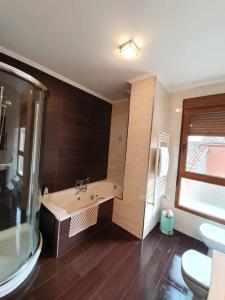 a bathroom with a tub and a sink and a toilet at Casa rural Los Bodones in Quintanilla Riopico +34 photos