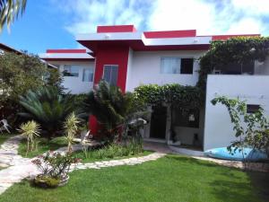 塞古羅港的住宿－Casa Frente Praia do mutá Porto Seguro，一座红色和白色的房子,有院子