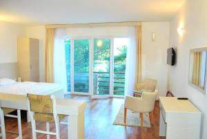 a living room with a table and chairs in a room at Hotel Art Media in Herceg-Novi