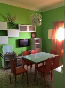 comedor con paredes verdes, mesa y sillas en Casa Garome 14 PARKING GRATIS, en Santa Cruz de la Palma