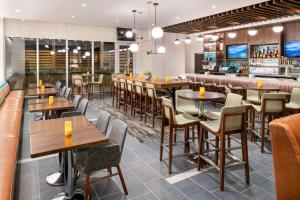 un restaurante con mesas y sillas y un bar en Hyatt Place East Moline/Quad Cities, en East Moline