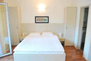a bedroom with a white bed and a mirror at Hotel Art Media in Herceg-Novi