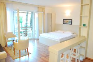 a bedroom with a bed and a desk and a balcony at Hotel Art Media in Herceg-Novi
