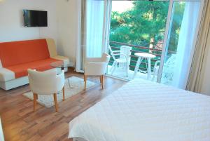 a bedroom with a bed and a couch and a balcony at Hotel Art Media in Herceg-Novi