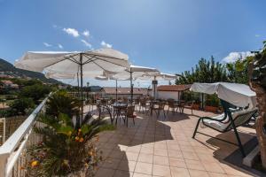 a patio with tables and chairs and umbrellas at Sant'Anna Bed & Breakfast in Agerola