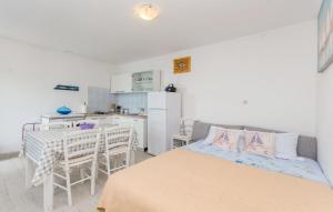 a bedroom with a bed and a table and a kitchen at House Island Harbour in Pašman