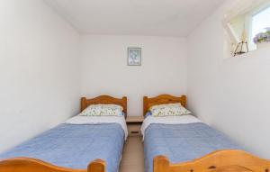 two twin beds in a room with a window at House Island Harbour in Pašman