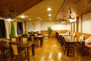 a dining room with wooden tables and chairs at Do Sports Plaza Madarao in Iiyama