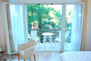 a room with a balcony with a table and chairs at Hotel Art Media in Herceg-Novi