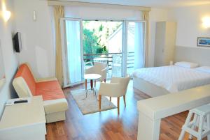 a bedroom with a bed and a table and chairs at Hotel Art Media in Herceg-Novi