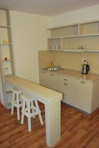 a kitchen with a counter and a table and stools at Hotel Art Media in Herceg-Novi
