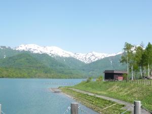 飯山市的住宿－斑尾運動旅館，享有以山脉为背景的湖泊美景