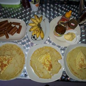 a table topped with plates of food with bananas and hot dogs at Room 2 in Mulu