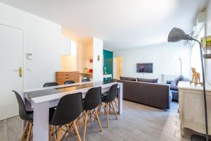 a kitchen and living room with a table and chairs at Family Travel Paris 3 in Bussy-Saint-Georges