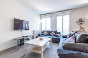 a living room with a couch and a table at Family Travel Paris 3 in Bussy-Saint-Georges