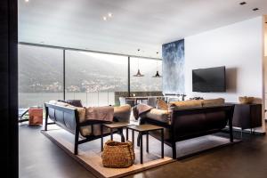 a living room with a couch and chairs and a television at Marvelous Lake Destination eco-friendly villa in Brienno