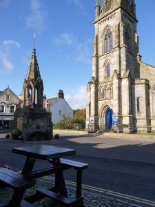 uma mesa de piquenique em frente a uma velha igreja em The Covenanter Hotel em Falkland mais 23 fotografias