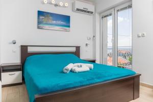 a bedroom with a bed with blue sheets and a window at Guest House Sidro - Wellness & Restaurant in Selce +70 photos