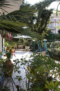 un jardín con un parque infantil con un columpio azul en Hotel Ornella, en Lido di Camaiore