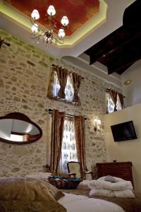 - une chambre avec un lit et un lustre dans l'établissement Antica Dimora Suites, à Réthymnon