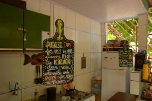 uma cozinha com um sinal de garrafa na parede em Hostel MPB Ilha Grande em Abraão
