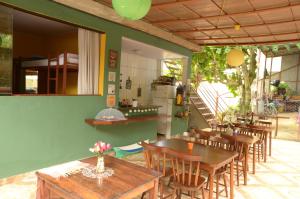 a restaurant with wooden tables and chairs and a staircase at Hostel MPB Ilha Grande in Abraão
