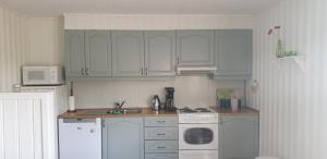 a kitchen with white cabinets and a stove top oven at Vesterålen - Lofoten Apartments 8475 Straumsjøen in Hovden