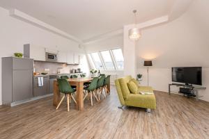 a living room with a table and chairs and a kitchen at Apartments Rosenthal Residence in Berlin