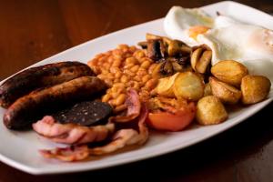 a plate of breakfast food with sausage beans and eggs at Radstock Hotel near Bath in Radstock