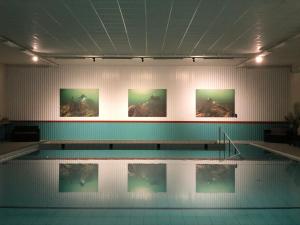 a swimming pool with four pictures on the wall at Gotlands Idrottscenter Vandrarhem in Fårösund