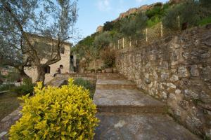 una pared de piedra con escaleras y flores amarillas en Levantes Mansion, en Karitena