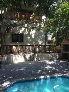 un patio trasero con piscina y terraza de madera en Turaco Guest House, en St Lucia