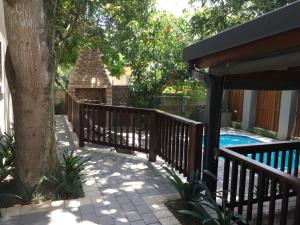 St Lucia的住宿－Turaco Guest House，环绕着一棵树的木栅栏,靠近游泳池