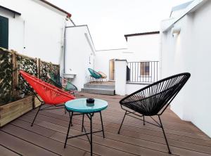 patio con 3 sedie e tavolo su una terrazza di Tric Trac Hostel a Napoli