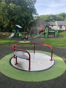 a park with a playground with a play equipment at Trail Lodge in Ballasalla