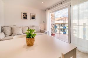 ein Wohnzimmer mit einem Sofa und einem Tisch in der Unterkunft Hauzify I Apartament Rosa dels Vents in Santa Susanna