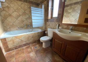 ein Badezimmer mit Badewanne, Toilette und Waschbecken in der Unterkunft Elaionas Zeliou in Nafpaktos