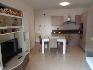 a kitchen and dining room with a table and a television at Terrapiana Home in Rosà