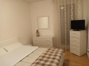 a bedroom with a bed and a tv on a dresser at Terrapiana Home in Rosà