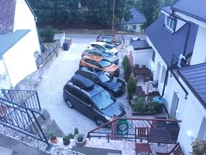 eine Gruppe von Autos, die auf einem Parkplatz geparkt sind in der Unterkunft Spa & Pool Apartment Hotel - Restaurant VILLA IVICA in Bratislava