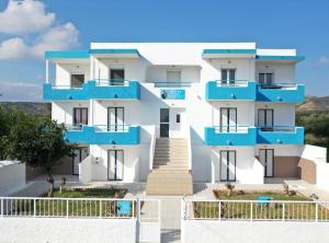 un edificio bianco e blu con balconi blu di Pittas Studios a Kardámaina