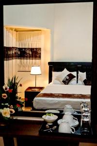 1 dormitorio con 1 cama y 1 mesa con set de té en SUNSET HILLS en Kandy