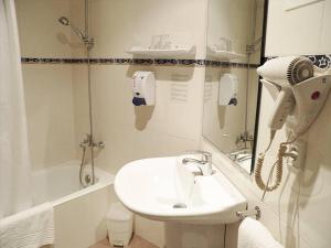 a white bathroom with a sink and a hair dryer at Hotel Europa in Girona +21 photos