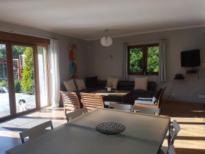 uma sala de estar com um sofá, uma mesa e cadeiras em WIGWAM Dom z basenem na Kaszubach em Sulęczyno