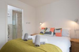 a bedroom with a large white bed with a shower at Blaeberry Cottage in Aviemore