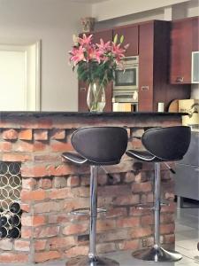 a counter with two stools in a kitchen with a brick wall at Perfect getaway, seafront home in Bangor